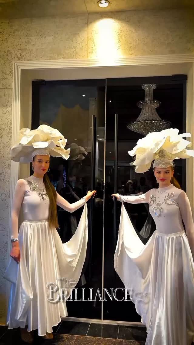 Welcome performers in sculptural white headpieces at a gala